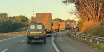 Grande comboio parte para o Sul por estrada, trilhos e mar