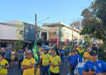 Com bandeira dos EUA e toalha do Bolsonaro, apoiadores marcham em frente ao Choppão