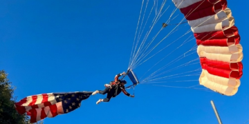 VÍDEO: Paraquedista amarrado a bandeira gigante dos EUA se enrosca em árvore e cai sobre tenda