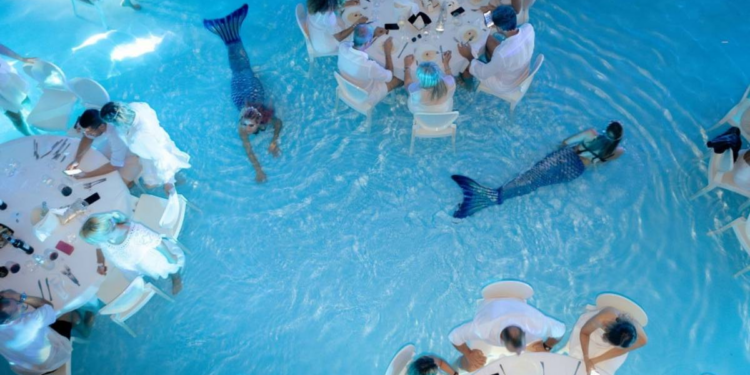 Jantar dentro de piscina com 'sereia' entre mesas viraliza e rende piadas no Brasil; conheça