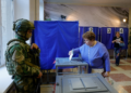 Vigiados por militares armados, ucranianos de região ocupada pela Rússia votam em eleição parlamentar russa; veja FOTOS